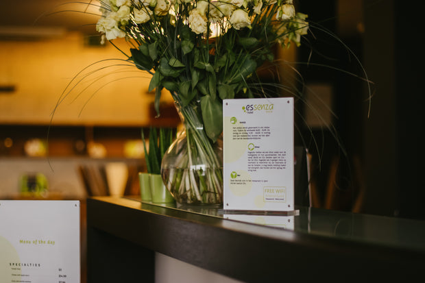 Acryl informatie display op toonbank met bloemenvaas in hotel